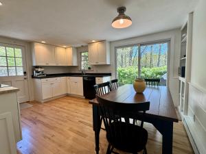 a kitchen with a wooden table and chairs in a kitchen at The Brewster Pearl in Brewster
