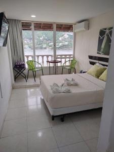 a bedroom with a bed and a table and chairs at Hotel Bahia Taganga in Taganga