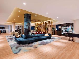 a large living room with a couch and a column at Novotel The Hague World Forum in The Hague