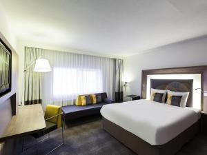 ein Hotelzimmer mit einem großen Bett und einer Couch in der Unterkunft Novotel The Hague World Forum in Den Haag + 72 Fotos