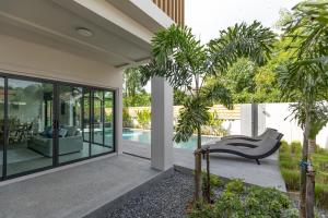 a patio with a chair and a swimming pool at Sleep With Sheep - 3 Bedroom Pool Villa in Chiang Mai