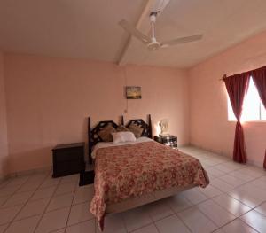 une chambre avec un lit et un ventilateur de plafond dans l'établissement Hotel Melyvan, à San Carlos