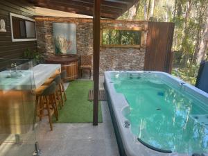 a jacuzzi tub in a patio with a table at Buddha's Bungalow in Byron Bay