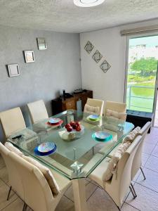 a dining room with a glass table and chairs at Departamento zona Diamante in Acapulco