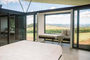 a bedroom with a bed and a large window at Maleny Scenic Retreat in Booroobin