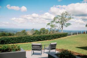 BooroobinにあるMaleny Scenic Retreatの芝生のパティオに置かれた2脚の椅子