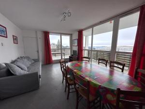 una sala de estar con una mesa y un sofá en Appartement spacieux pour 7, proche des pistes à Super Besse - FR-1-814-154, en Super Besse