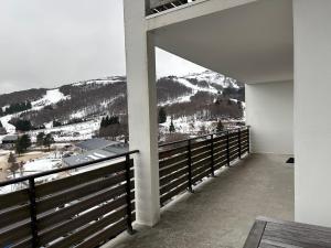 balcón con vistas a una montaña nevada en Appartement spacieux pour 7, proche des pistes à Super Besse - FR-1-814-154, en Super Besse