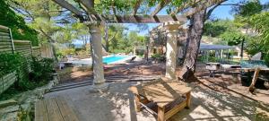 a pergola with a bench next to a pool at Mas du Cigalin in Pernes-les-Fontaines