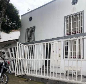 a white house with a white fence in front of it at Duplex casa 1 in Cali