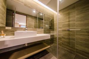 a bathroom with a sink and a glass shower at Palm Tree Hotel Kenting in Kenting