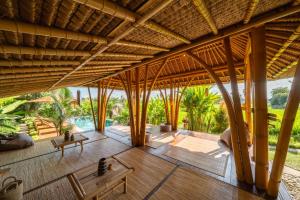 an open living room with a large bamboo ceiling at Rumah Kita Ecolodge in Ubud
