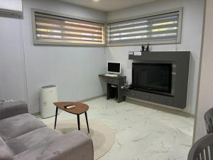 a living room with a couch and a tv at Gapyeong The Haru Emotional Pool Villa in Mŏk-kol