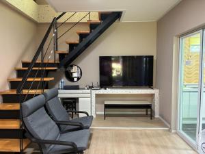 a living room with a tv and a chair and a table at Gapyeong The Haru Emotional Pool Villa in Mŏk-kol