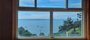a window with a view of a body of water at Boseong Deukryangman Pension in Boseong