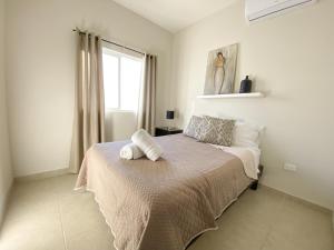 a bedroom with a bed with two towels on it at Casa Atardecer con Alberca en Privada, 5 min del Aeropuerto y Consulado Americano in Hermosillo +27 photos