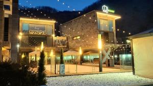 a building with lights in front of it at night at Avec J Pool Villa in Samgŏ-ri