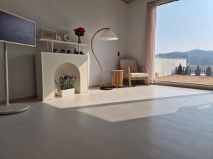 a living room with a fireplace and a large window at Gapyeong Relaxing Pension in Yŏnbyŏn