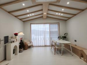 a living room with a table and a window at Gapyeong Relaxing Pension in Yŏnbyŏn