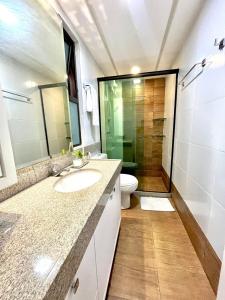 a bathroom with a sink and a toilet and a shower at Flat espaçoso e confortavel no hotel Canarius Gravata in Gravatá