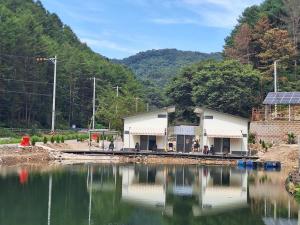 ein Gebäude neben einem Gewässer in der Unterkunft Chuncheon Cracra Pension in Madang-gol