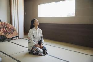 a woman in a kimono sitting on the floor at Ryokan Hotel Usagi in Chuncheon