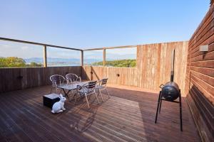 a balcony with a table and chairs and a grill at Ryokan Hotel Usagi in Chuncheon