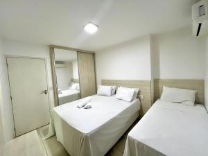 a small room with two beds and a mirror at Flat espaçoso e confortavel no hotel Canarius Gravata in Gravatá +47 photos