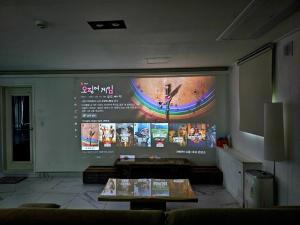 ein Raum mit einer großen Wand mit einem großen Bildschirm in der Unterkunft Gapyeong Pool Villa Pension Belloci Lake in Hakik-tong