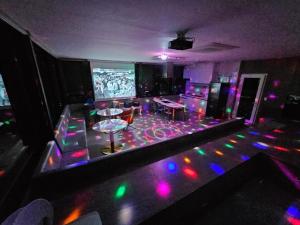 ein Raum mit bunten Lichtern auf einer Tanzfläche in der Unterkunft Gapyeong Pool Villa Pension Belloci Lake in Hakik-tong