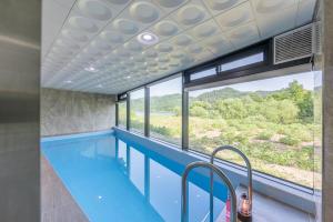 einen Pool mit großem Fenster in einem Haus in der Unterkunft Gapyeong Pool Villa Pension Belloci Lake in Hakik-tong