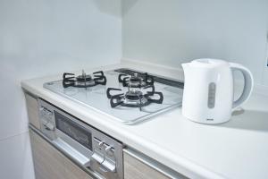 a kitchen with a stove top with a jug on the counter at Homey Inn SANNO in Kyoto