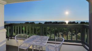 a table and chairs on a balcony with the ocean at Taean Janggong Pension in Yangjimal