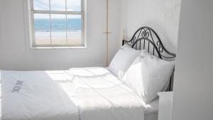 a bedroom with a bed with white sheets and a window at Taean Janggong Pension in Yangjimal