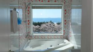 a bathroom with a bath tub and a window at Taean Janggong Pension in Yangjimal +75 photos