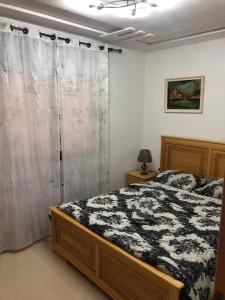 a bedroom with a bed with a black and white comforter at La Brise Saidia in Saïdia