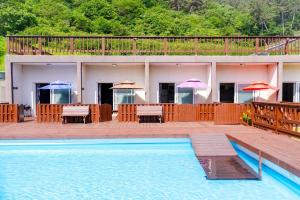 a resort with a swimming pool and tables and umbrellas at Taean Low Stack Pet Pension in Taean