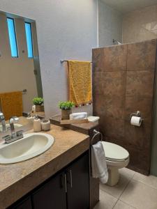 une salle de bain avec un lavabo, des toilettes et un miroir dans l'établissement Casa Altozano Confort, à Morelia 9 autres photos