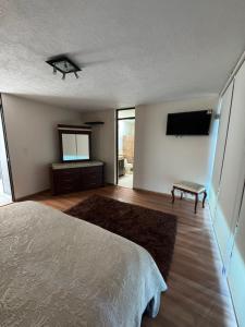 une chambre avec un lit et une télévision à écran plat dans l'établissement Casa Altozano Confort, à Morelia