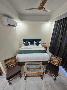 a bedroom with a bed with two chairs and a table at Siddhi Retreat hotel in Rishīkesh