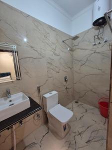 a bathroom with a white toilet and a sink at Siddhi Retreat hotel in Rishīkesh