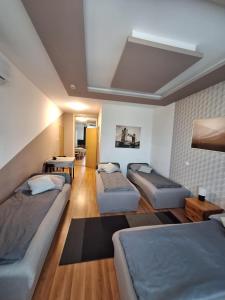 a room with four beds in it with a ceiling at Velvet Motel in Hegyeshalom