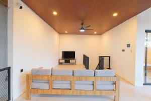 a living room with a bed and a flat screen tv at 4BR Modern Villa walking dist to Sidewalk Jimbaran in Jimbaran