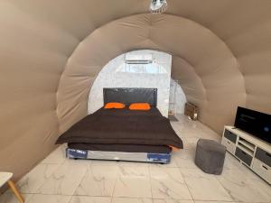 a bed with two orange pillows in a tent at Yuuhi Villa Glamping in Mancagahar