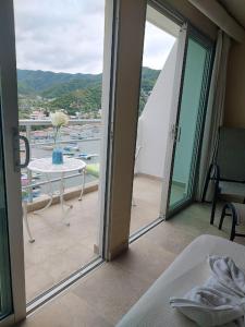 Cette chambre dispose d'une porte s'ouvrant sur un balcon avec une table. dans l'établissement Hotel Bahia Taganga, à Taganga
