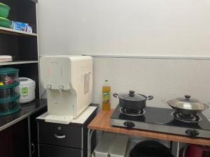 a kitchen with a mixer and two pans on a stove at Aileen Homestay Swimming Pool in Batu Gajah