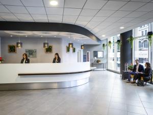 a lobby with people sitting at a reception desk at Novotel Reading Centre in Reading