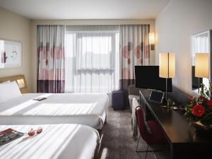a hotel room with two beds and a desk at Novotel Reading Centre in Reading