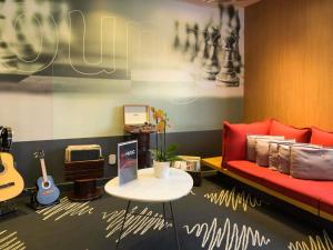 a living room with a red couch and a table at ibis Aracaju in Aracaju