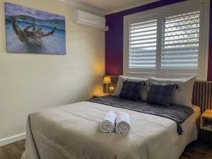 a bedroom with a bed with two white towels on it at Quarterdeck Apartments in Gladstone